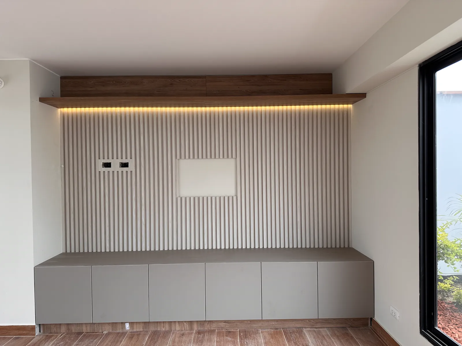 Área común con muebles y paneles de madera del proyecto Dalias