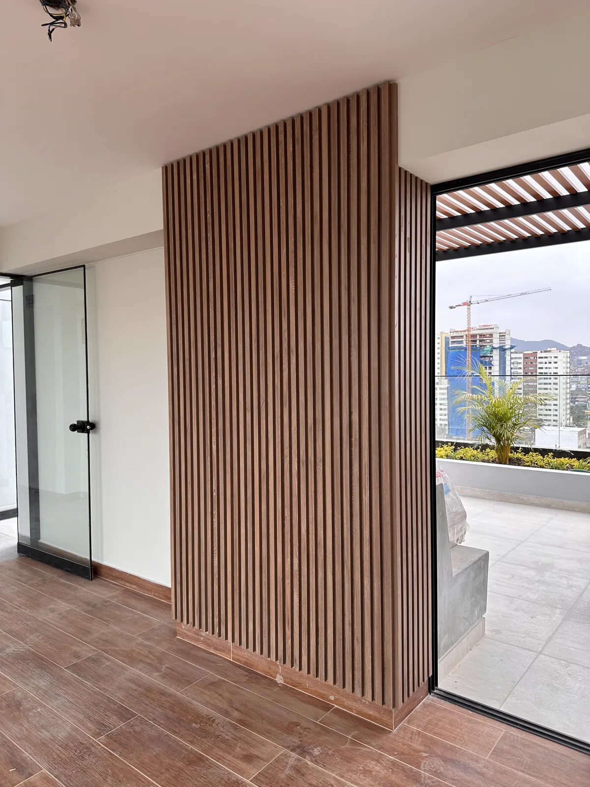 Área común con muebles y paneles de madera del proyecto Dalias