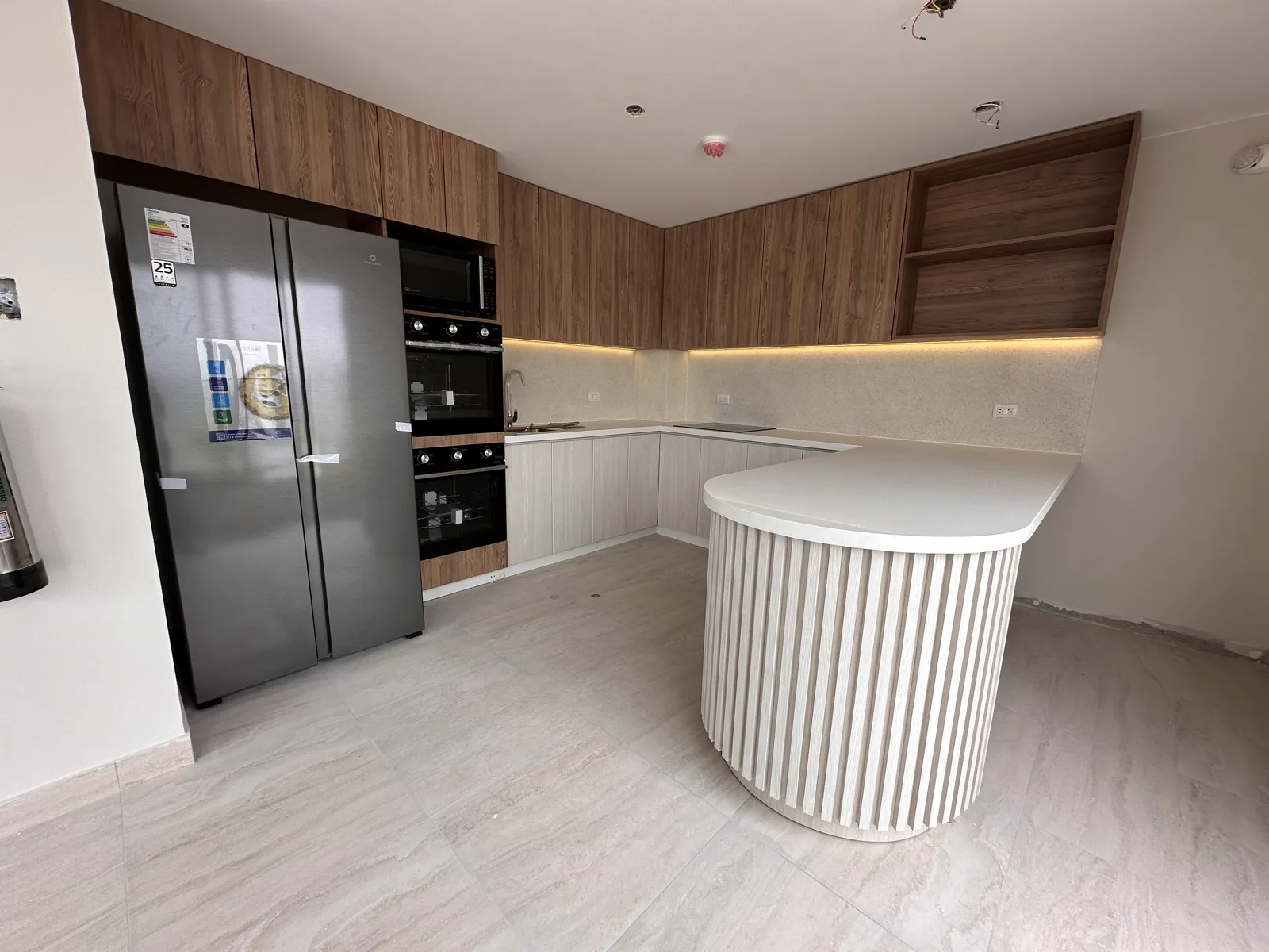 Área común con muebles y paneles de madera del proyecto Dalias