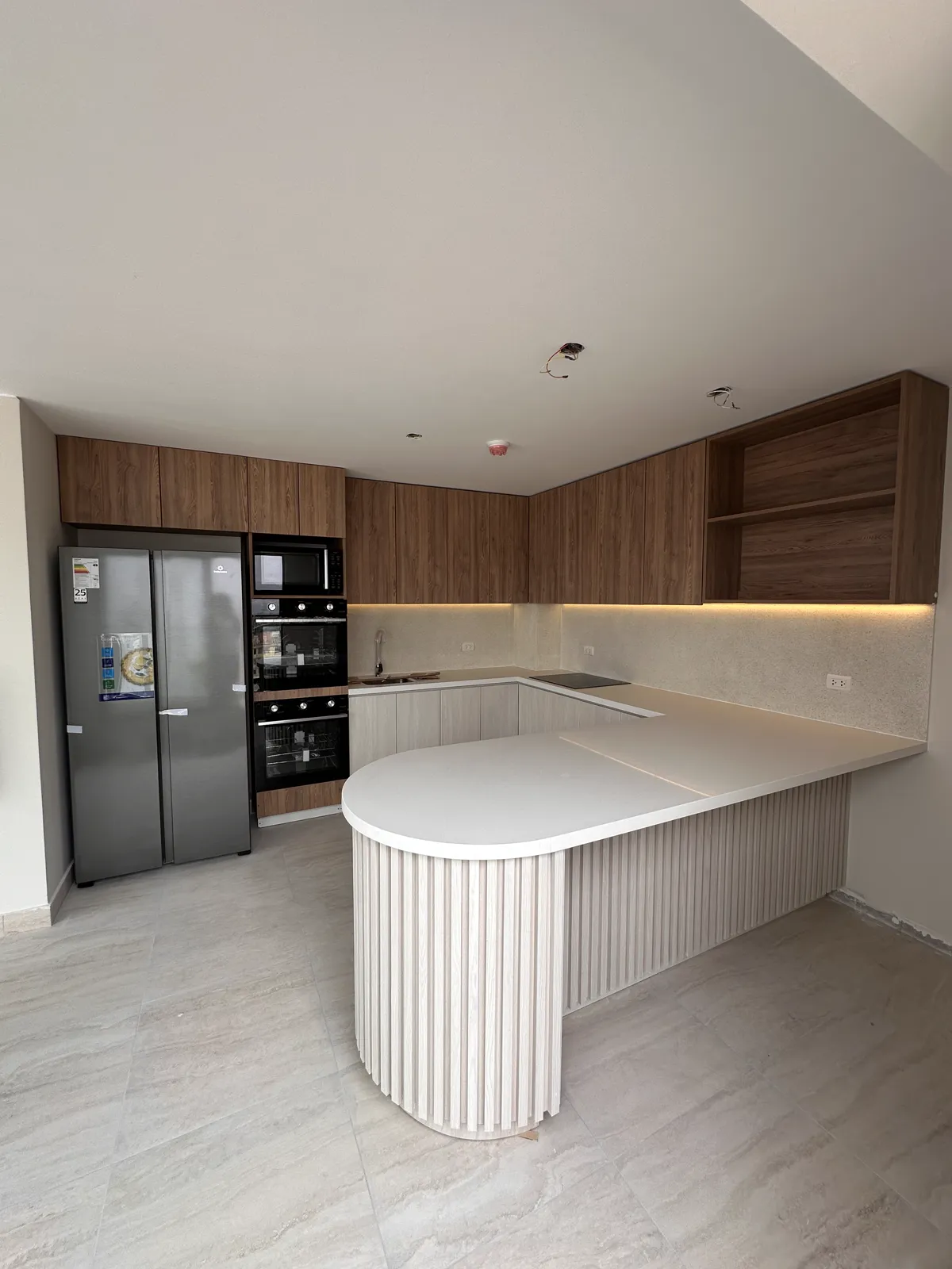 Área común con muebles y paneles de madera del proyecto Dalias