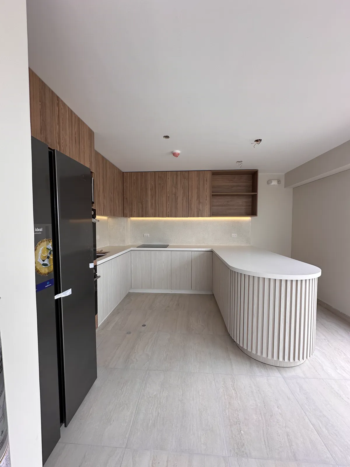 Área común con muebles y paneles de madera del proyecto Dalias