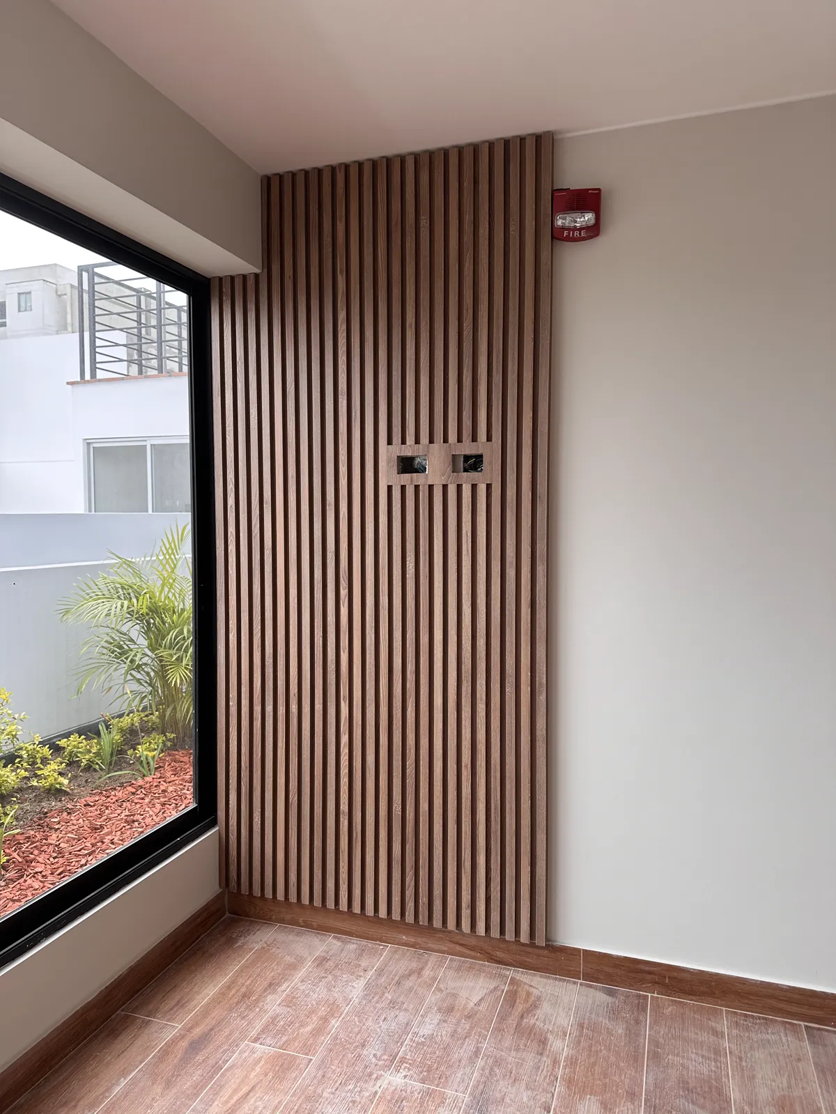 Área común con muebles y paneles de madera del proyecto Dalias