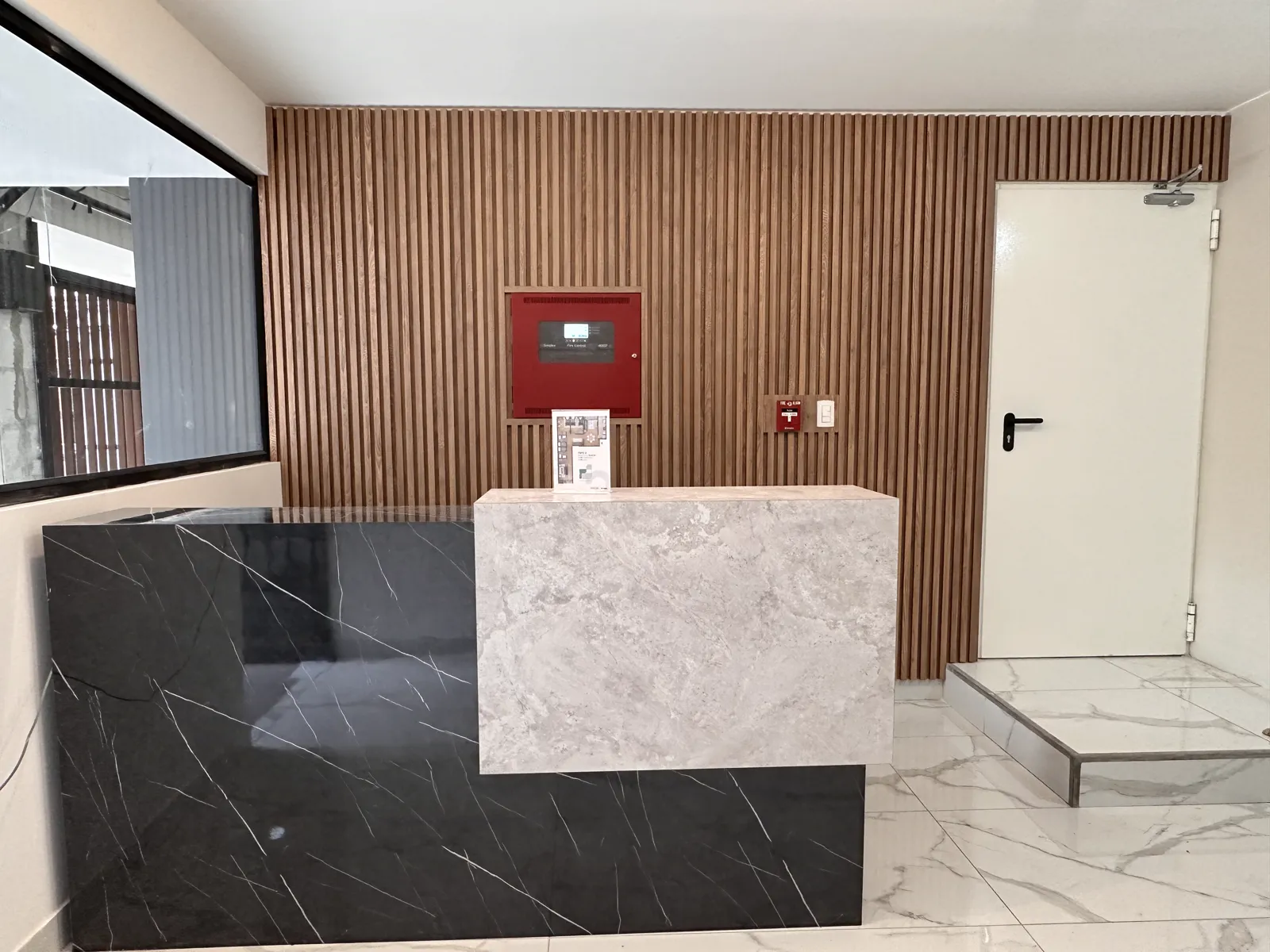 Área común con muebles y paneles de madera del proyecto Dalias